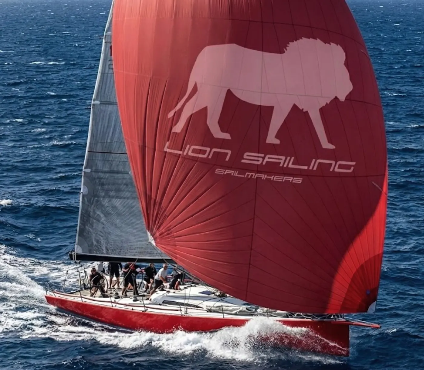 A Lion Sailing red spinnaker with the lion on it, flying downwind